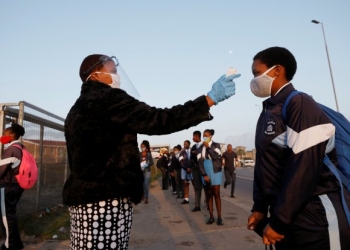 FILE PHOTO: A learner is screened as schools begin to reopen after the coronavirus disease (COVID-19) lockdown in Langa township in Cape Town, South Africa June 8, 2020. REUTERS/Mike Hutchings/File Photo