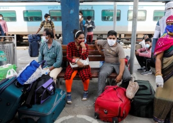 Passengers sit with their belongings at a platform as they wait to board a train at a railway station after a few restrictions were lifted during an extended nationwide lockdown to slow the spread of the coronavirus disease (COVID-19), in New Delhi, India, June 1, 2020. REUTERS/Adnan Abidi