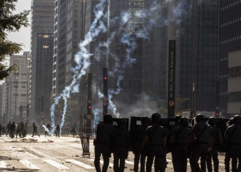 Police clash with anti-government demonstrators in Sao Paulo, Brazil, Sunday, May 31, 2020. Police used tear gas to disperse anti-government protesters in Brazil's largest city as they began to clash with small groups loyal to President Jair Bolsonaro. (AP Photo/Andre Penner)