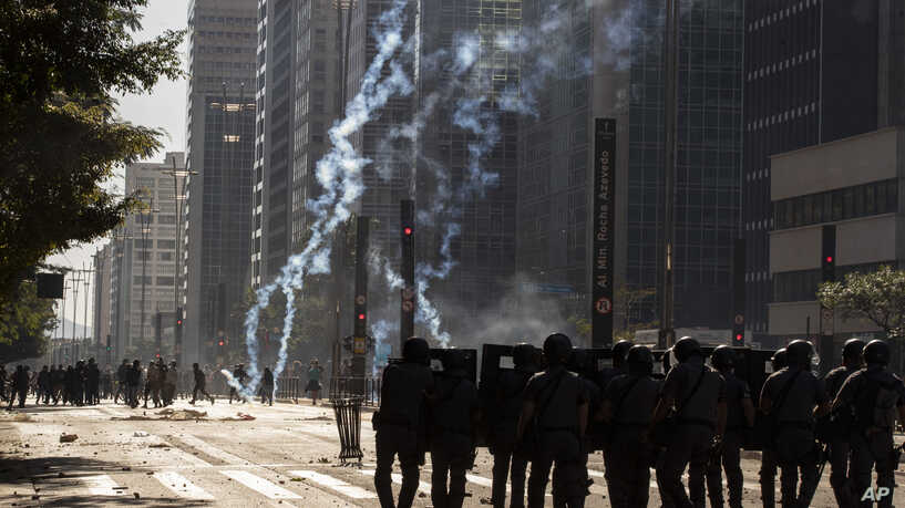 Police clash with anti-government demonstrators in Sao Paulo, Brazil, Sunday, May 31, 2020. Police used tear gas to disperse anti-government protesters in Brazil's largest city as they began to clash with small groups loyal to President Jair Bolsonaro. (AP Photo/Andre Penner)