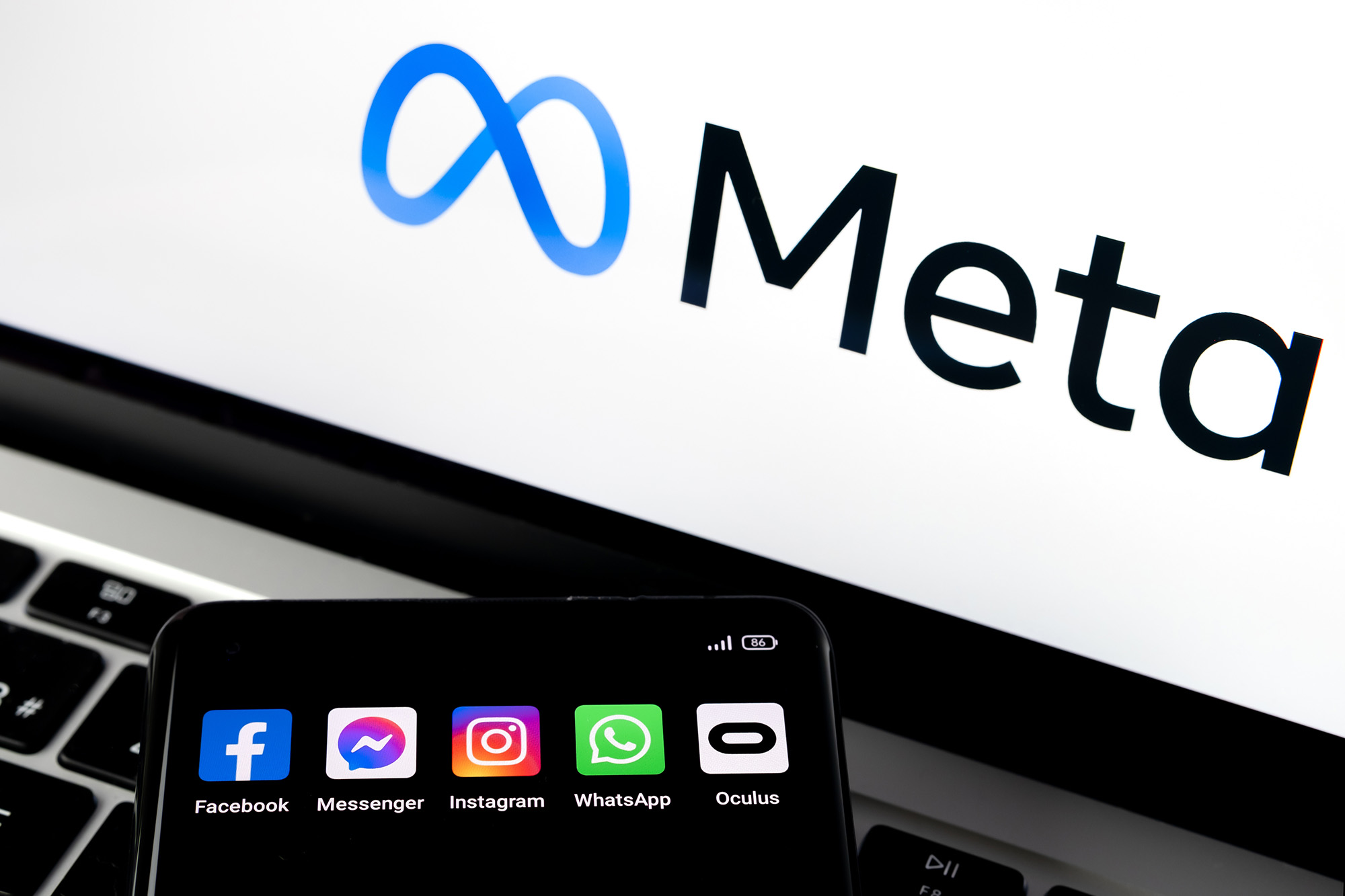 METAVERSE META FACEBOOK. Silhouette of smartphone with Facebook, Messenger, whatsApp, Instagram, Oculus apps and blurred META logo on background. Rebrand of Facebook. Stafford, UK, October 28, 2021
